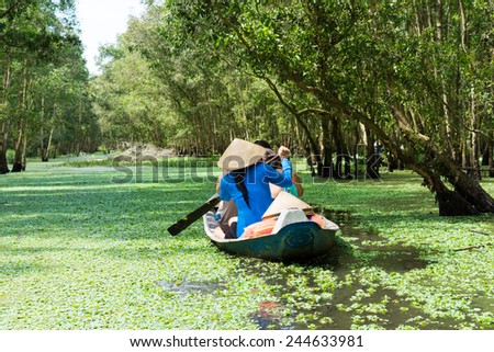 Tourism rowing boat in Tra Su flooded indigo plant forest in An Giang, Mekong delta, Vietnam