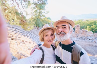 Tourism And Technology. Traveling Senior Couple Taking Selfie Together Against Ancient Sightseeing Background.