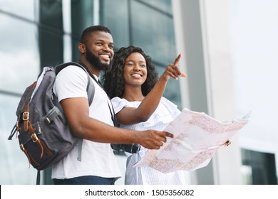 Tourism And Travel. Happy African Millennials Searching New City With Map, Standing At Airport, Empty Space