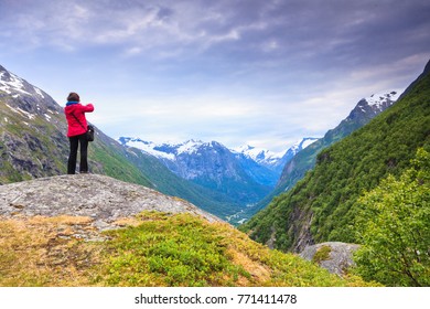 Tourism vacation and travel. Female tourist taking picture with camera, enjoying scenic summer mountains landscape, Norway Scandinavia. - Shutterstock ID 771411478