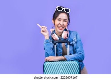 Tourist asian woman in casual clothes hat hold suitcase using mobile cell phone sit isolated on colour background Passenger travel abroad weekends .