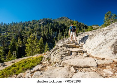 Tourist With Backpack Hiking In Mountains At Lake Tahoe In California, USA