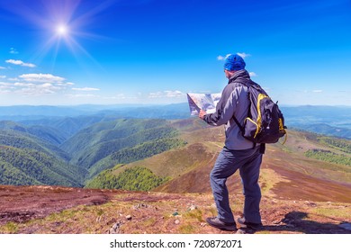 Tourist with a backpack and a map in the mountain - Powered by Shutterstock