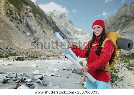 Tourist with backpack and map in mountains