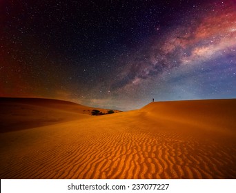 Tourist with backpack standing on top of a mountain and enjoying night sky view with stars. - Powered by Shutterstock