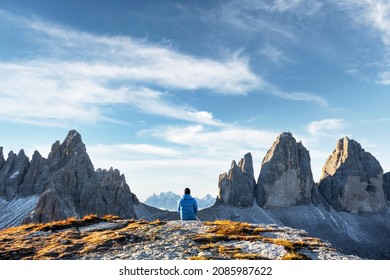 Tourist in blue jacket at Three Peaks of Lavaredo track on autumn season. National Park Tre Cime di Lavaredo, Dolomite Alps mountains, Trentino Alto Adige region, Sudtirol, Dolomites, Italy