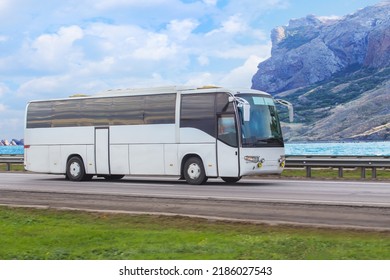 Tourist bus moves along the mountains on the sea coast