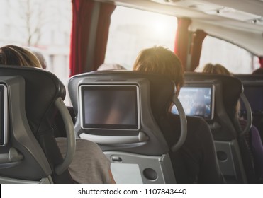 Tourist bus with passengers and built-in LCD tablets.