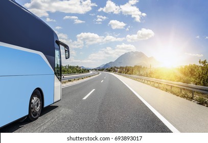 Tourist bus rushes along the asphalt high-speed highway.