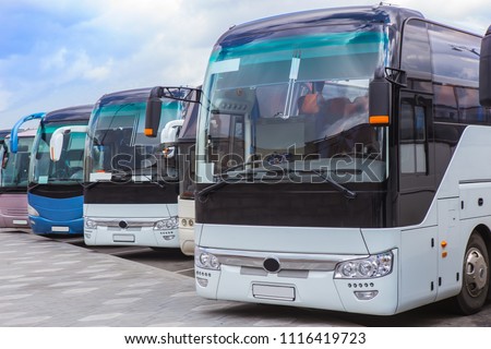 tourist buses on parking on the background of cloudy sky