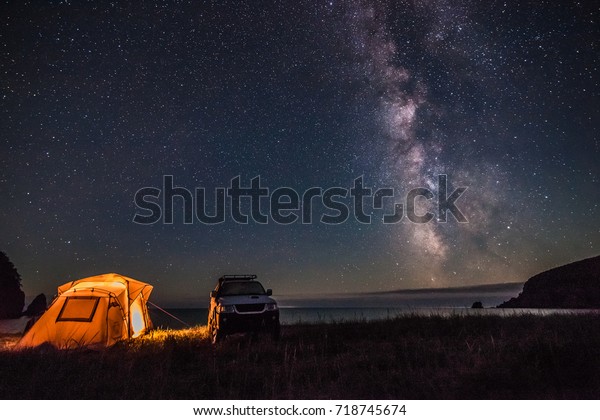 Tourist camping at sea coast at night with
milky way. Some noise from hugh iso
exists