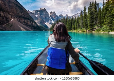 Tourist Canoeing On Moraine Lake In Banff National Park, Canadian Rockies, Alberta, Canada.