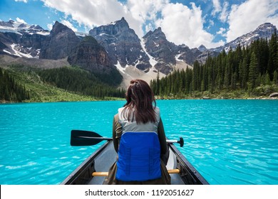 Tourist Canoeing On Moraine Lake In Banff National Park, Canadian Rockies, Alberta, Canada.