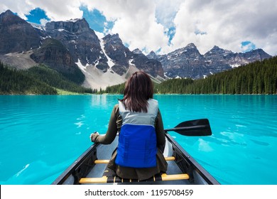 Tourist Canoeing On Moraine Lake In Banff National Park, Canadian Rockies, Alberta, Canada.