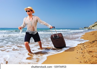 A tourist carrying a suitcase at the beach Peroulades at Corfu island, Greece