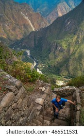 Tourist Climbing Old Incan Stairs To The Top Of Wayna Picchu For The Views Of Machu Picchu, Peru