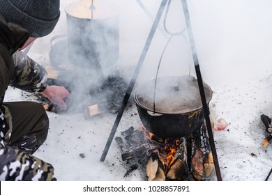 Tourist Cooking Food On Bonfire, Cooking On Snow In Winter. Preparation Food For Breakfast, Lunch And Dinner