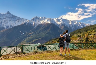 Tourist couple enjoy view of the majestic Kailash Himalaya range from Kalpa Himachal Pradesh, India