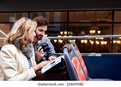 Tourist Couple On Open Top Bus Tour Guide Around The City In Vacation