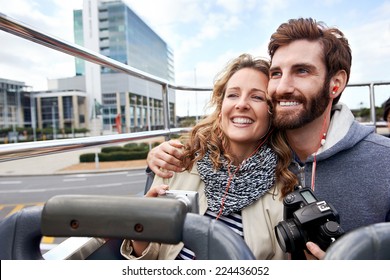 Tourist Couple On Open Top Bus Tour Guide Around The City In Vacation