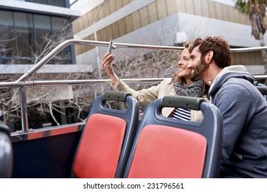 tourist couple travel selfie on open top tour bus in city