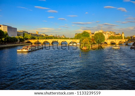 Tourist cruise on Seine river. Bateau mouche from Pont Neuf bridge and Notre Dame church on background. Tourist travelers in popular landmarks of Paris in France at sunset from Pont des Arts bridge.