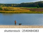 Tourist with a dog exploring Stawy Echo (Echo Ponds), a part of Roztoczanski National Park, Poland