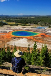 Tourist Enjoying The View Of Grand Prismatic Spring In Midway Geyser Basin, Yellowstone National Park, Wyoming, USA. It Is The Largest Hot Spring In The United States