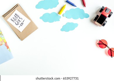 tourist equipment with toys and notebook for traveling with kids on white background top view mock up