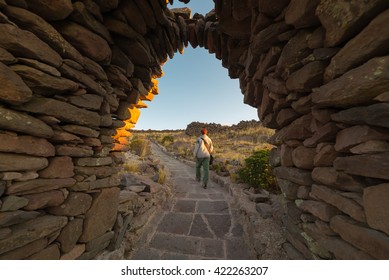 Tourist exploring Inca trails at sunset on Amantani' Island, Titicaca Lake, among the most scenic travel destination in Peru. Travel adventures and vacations in the Americas.