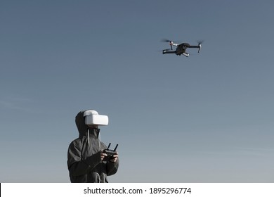 Tourist exploring new places. Drone pilot on nature with quadcopter. Using drone while standing near lake. Young person  with drone and virtual reality viewer.