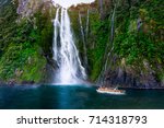 Tourist ferry carrying people approaching Stirling Falls at Milford Sound in South Island of New Zealand.