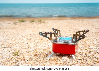 Tourist Gas Burner On The Beach. Portable Travel Gas Hob. Background With Copy Space.