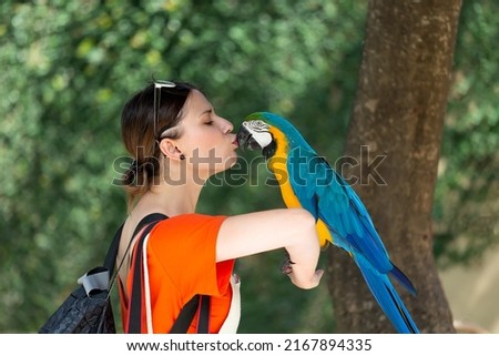 Tourist girl kisses a parrot. Ubud. Bali, Indonesia