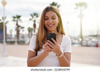 Tourist girl looking for hotel on mobile phone. Traveler woman using mobile phone booking a room for the night. Last minute travels concept.