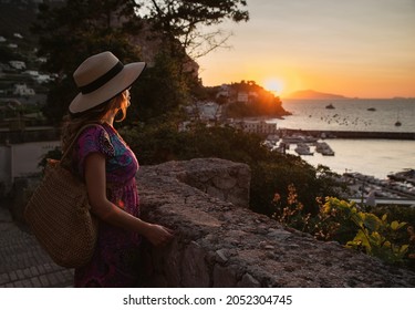 Tourist girl in Marina Grande, Capri watching sunset