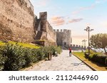 Tourist girl visitor walks to the entrance of the Trigonion or Chain Tower in Upper Town of Ano poli in Thessaloniki, Greece