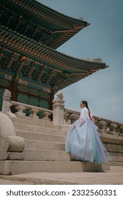 Tourist girl wearing a traditional korean hanbok at the Gyeongbokgung Palace in Seoul, South Korea.