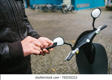 The tourist is going to use the electric scooter through the mobile application in the phone and distally activate it. A popular vehicle in Berlin and Paris.