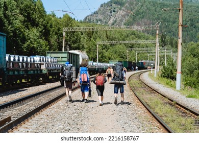 A Tourist Group Goes Hiking Up The Mountain With Large Backpacks, Walking Together On Sleepers, The Road To The Mountains, Summer Vacations In Nature, A Joint Adventure. High Quality Photo