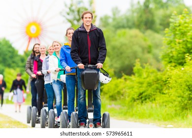 Tourist Group Having Guided Segway Theme Park Tour