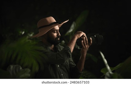 Tourist guy holding camera and taking picture of nature, Wildlife photography concept image, Young man in the forest  - Powered by Shutterstock