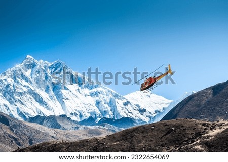 Tourist helicopter in Himalaya mountains, Nepal.. View of Taboche peak in Khumbu valley, Everest region, Nepal. Autumn landscape