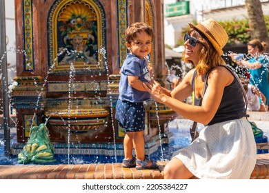 A Tourist With Her Son At The Water Fountain In The Plaza De España In Vejer De La Frontera, Cadiz