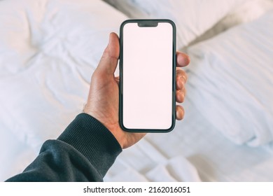 Tourist In Hotel Bedroom Holding Smartphone With Blank Mockup Screen For Booking And Reservation App Or Accommodation Rating Service