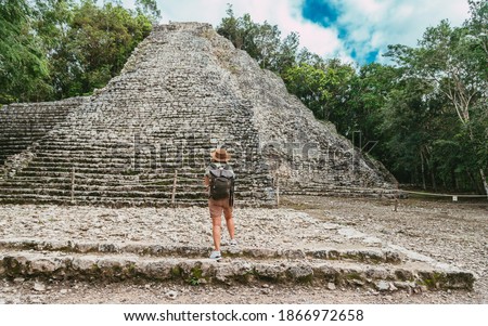Tourist in the jungle with a backpack and a hat. Tourism in the ancient city Mayan pyramids