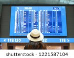 Tourist is looking at flight table in the Airport.                               