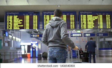 Tourist Looking At Time Table, Checking Schedule On Screen In Bus Terminal