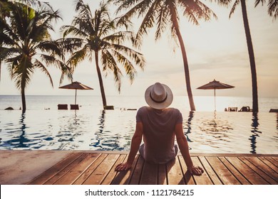 Tourist In Luxury Beach Hotel Near Luxurious Swimming Pool At Sunset, Getaway, Tropical Exotic Holidays Vacation, Tourism And Travel