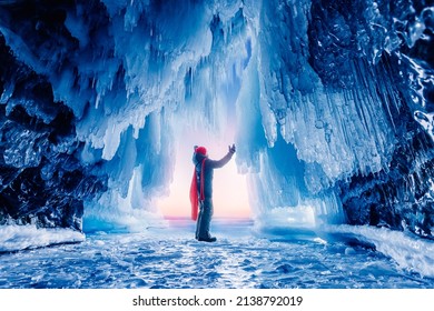 Tourist Man In Ice Blue Cave Or Grotto On Frozen Lake Baikal. Concept Beautiful Adventure Travel Winter Landscape With People.